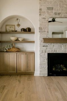 a living room filled with furniture and a fire place in front of a brick fireplace