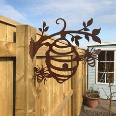 a wooden fence with a metal bee on it