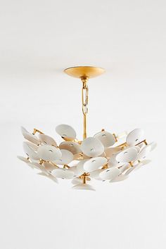 a chandelier with many white birds hanging from it's ceiling light fixture