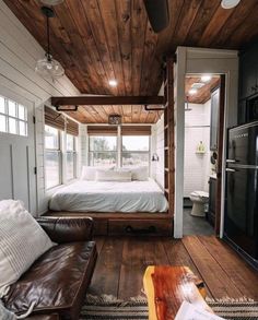 a living area with couch, bed and window