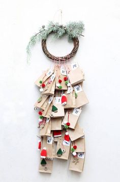 a bunch of tags hanging on a wall with a wreath around them that says christmas