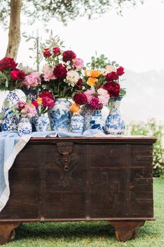 an old trunk with vases and flowers on it