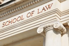 the school of law sign is on the side of a building with columns and pillars