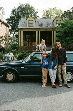 a family standing in front of their car