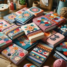 there are many crocheted notebooks on the table