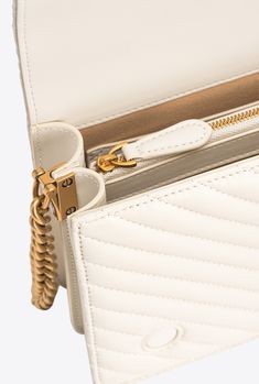 Classic Love Bag Click in quilted nappa leather with chevron design. The concealed press-stud fastening is embellished by the iconic metal Love Birds Diamond Cut buckle with cut-out effect. The accessory boasts a suede-look microfibre-lined interior, complete with a zipped centre divider pocket and slip pocket. The shoulder strap combines the round-link metal chain with a practical, adjustable leather shoulder pad. Activate your PINKO bag: verify the authenticity of your product and access a per White Quilted Bag For Formal Occasions, Elegant White Quilted Bag, Luxury Quilted Cream Shoulder Bag, White Quilted Evening Bag, Gold Quilted Bag For Everyday Luxury, Gold Quilted Top Handle Bag, Classic Gold Quilted Bag, Classic Quilted Gold Bag, Classic Love