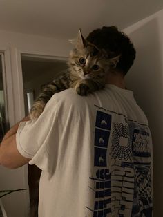 a man holding a cat on his back