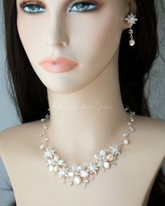 Composed of Keshi pearl flowers, alternating jeweled flower components, and Swarovski crystal beads, this gorgeous beach inspired necklace and earring set will compliment you mermaid or beach themed event. This elegant and glamorous piece will accent any gown or ensemble, making it the perfect accessory set that adds a hint of sparkle for your special occasion. The necklace is 15.5 inches long with a 2.5 inch extender, 1.25 inch drop, the earrings are 1.5 inches long with post pierced backs. Lea White Beaded Jewelry For Beach Wedding, Silver Beaded Jewelry For Beach Wedding, Elegant Silver Jewelry For Beach Wedding, Pearl Flowers, Long Gown Dress, Inspired Necklace, Swarovski Crystal Beads, Keshi Pearls, Necklace And Earring Set