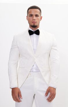 DETAILS This white tailored fit tuxedo is a unique and stylish option for any special or formal event. Features a raised laced texture of the fabric that creates depth and dimension, adding a tactile element to the jacket. Designed with a mandarin collar. which adds a touch of modernity to the jacket. As well as having a satin finish around the closure, giving a luxurious sheen to the outfit. Pair with any Tomson Tuxedo Pants SIZE + FIT Tailored fit, to find your correct size use the ''What's my Luxury Fitted Blazer For Ceremonies, White Fitted Tuxedo For Ceremony, White Tailored Suits For Ceremony, White Fitted Blazer For Ceremony, Tuxedo Style Blazer For Ceremonies, Tailored Tuxedo Blazer For Ceremonies, Luxury Tailored Blazer For Ceremonies, Tailored Luxury Blazer For Ceremony, Ceremony Tuxedo Blazer