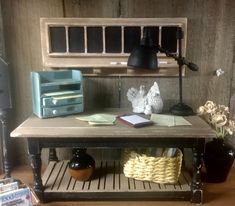 a table with some books and other items on it, next to a wall shelf