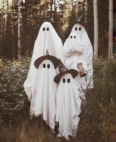 two people dressed up as ghost in the woods