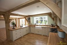 an empty kitchen with wooden floors and white cabinets, is pictured in this image from the inside