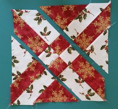 a quilted piece of fabric with holly and snowflakes on it, cut into squares