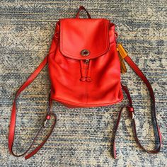 100% Authentic Leather Coach Mini Backpack In Vibrant Red Orange Pebbled Leather With Yellow Leather Hangtag. Never Used, New Without Tags. 9" X 10" X 4" Leather Exterior And Fabric Lining Top Handle With 4" Drop Silver Hardware Inside Zippered And Open Pockets Drawstring And Additional Turnlock For Secure Closure Adjustable Straps Red Leather Backpack With Zipper Closure, Classic Red Backpack For Daily Use, Classic Red Leather Backpack, Red Leather Standard Backpack, Red Leather Satchel Backpack For Travel, Red Leather Backpack Bag, Classic Red Standard Backpack, Red Crossbody Travel Backpack, Red Crossbody Backpack With Adjustable Strap