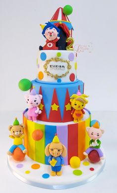 there is a multi layer cake decorated with clowns and circus animals on it's sides