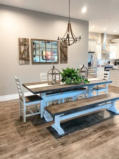 a dining room table and benches in front of a kitchen with an open floor plan