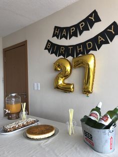 a 21st birthday party with balloons, cake and drinks on a table in front of the number twenty sign