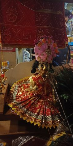 an elaborately decorated doll sitting on top of a table