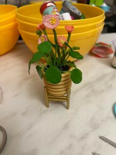 a small potted plant sitting on top of a table next to yellow bowls and utensils