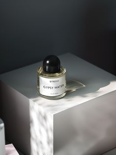 a bottle of perfume sitting on top of a white box