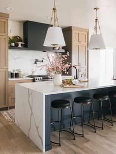 an image of a kitchen setting with bar stools in the center and countertop