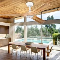 a large open kitchen and dining room with sliding glass doors leading to an outdoor swimming pool