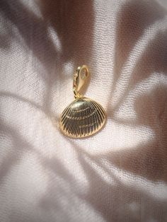 Add to your story with this gold sea shell charm. Choose from a regular jump loop or lobster clasp to make it your own.Planning on purchasing a chain for this and need help attaching it? Let us know and leave a note during checkout! This item will arrive separate/detached if no note is left.✦ DETAILS ✦✧ Gold Filled Sea Shell Pendant - 15mm x 17mm.✧ 14kt Gold Filled Loop or Clasp✧ Chains sold separately.✧ All Ke Aloha Jewelry pieces come packaged thoughtfully, beautifully, and ready for gift givi Yellow Gold-plated Charms With Lobster Clasp, Gold Shell-shaped Jewelry With Starfish Charm, Gold Jewelry With Starfish Charm, Gold Round Pendant Charm With Pearl, Gold Metal Jewelry With Starfish Charm, Gold Round Pendant Charm With Lobster Clasp, Elegant Gold Shell With Lobster Clasp, Brass Charms With Lobster Clasp For Gift, Gold Shell-shaped Charm Necklaces With Lobster Clasp