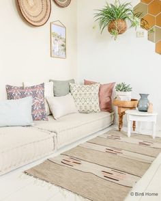 a living room filled with lots of furniture and decor on top of a white floor