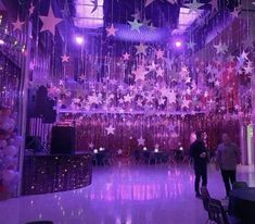 people are standing in the middle of a room decorated with stars and streamers hanging from the ceiling