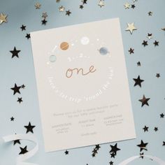 a birthday card with stars and confetti around it on a blue background that says one