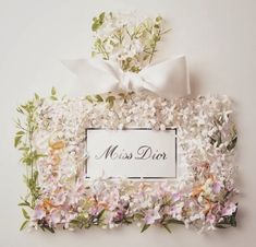 a white frame with flowers and a bow on the top that says miss dior