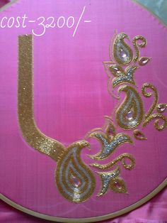 a pink and gold painted sign with an ornate design on it