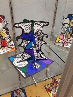 three colorful glass sculptures on display in a store