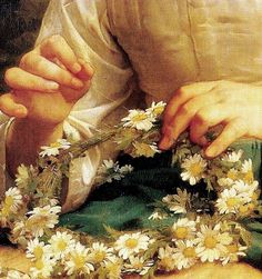 a close up of a person with flowers in their hands and one hand on the flower