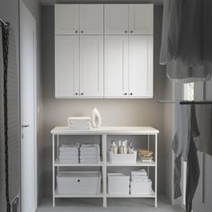 an organized bathroom with white cabinets and linens