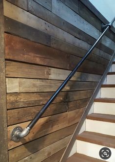 a wooden staircase with metal handrails and wood paneling