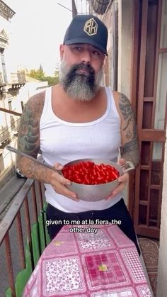 a man holding a bowl with strawberries in it