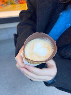 a person holding a cup filled with foamy liquid on top of it's side