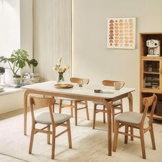 a table and chairs in a room with white walls