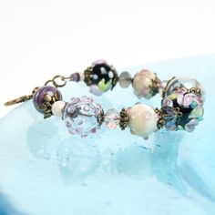 "This Pink flower lampwork boho bracelet is a perfect gift for women! This glass is rather durable as it is put in a very high temperature after the bead is made. This bracelet fits a 15.5-16.5cm (6.1\"-6.5\" inch) diameter wrist. If you need bigger or smaller size bracelet, please, write me the diameter of your wrist when making an order. Dimentions: 21cm. Materials: artist lampwork beads, metal and glass beads, metal fittings. Colors used: light pink, pink, ivory. Please, note, each lampwork b Whimsical Purple Beaded Jewelry, Bohemian Crystal Bracelet With Large Beads For Gift, Purple Bohemian Beaded Bracelets As Gift, Purple Large Beads Jewelry For Festival, Whimsical Colorful Beaded Bracelet, Handmade Purple Bohemian Beaded Bracelets, Bohemian Flower Bracelets With Colorful Beads, Handmade Vintage Purple Bracelets, Vintage Beaded Bracelets For Jewelry Making