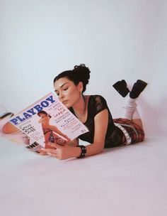 a woman laying on the floor reading a magazine