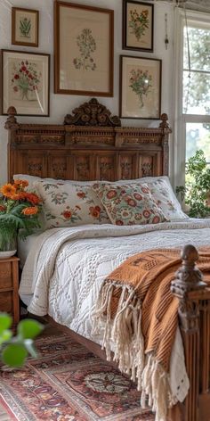 a bed sitting in the middle of a bedroom next to a window with pictures above it