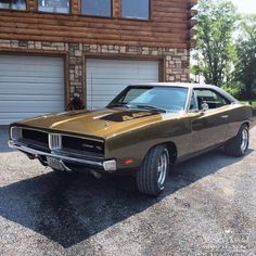 a brown muscle car parked in front of a house