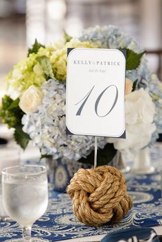 the table is set with blue and white floral centerpieces, napkins, and place cards