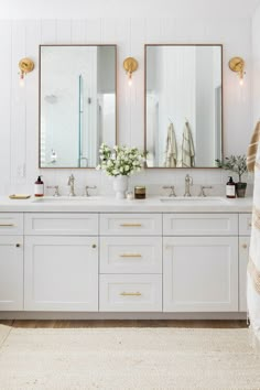 a bathroom with three mirrors and two sinks