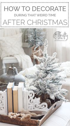 a christmas tree sitting on top of a wooden tray next to an open book and ornaments