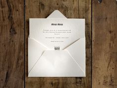 an envelope with the word mun on it is sitting on a wooden table next to a pair of scissors