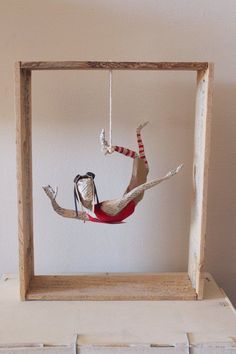 a wooden frame with a doll hanging from it