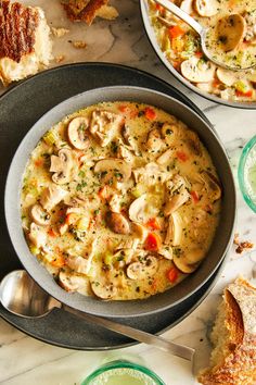 a pan filled with food on top of a table next to other plates and spoons