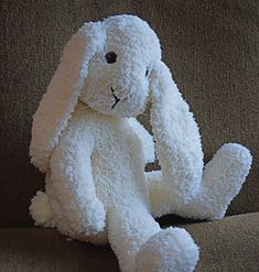 a white stuffed animal sitting on top of a couch